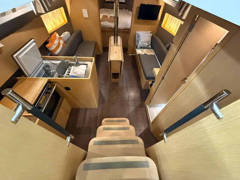 Slide: The Image of Interior of 2017 Beneteau Oceanis 38.1 yacht, featuring kitchen, seating, and cozy cabin. - 38