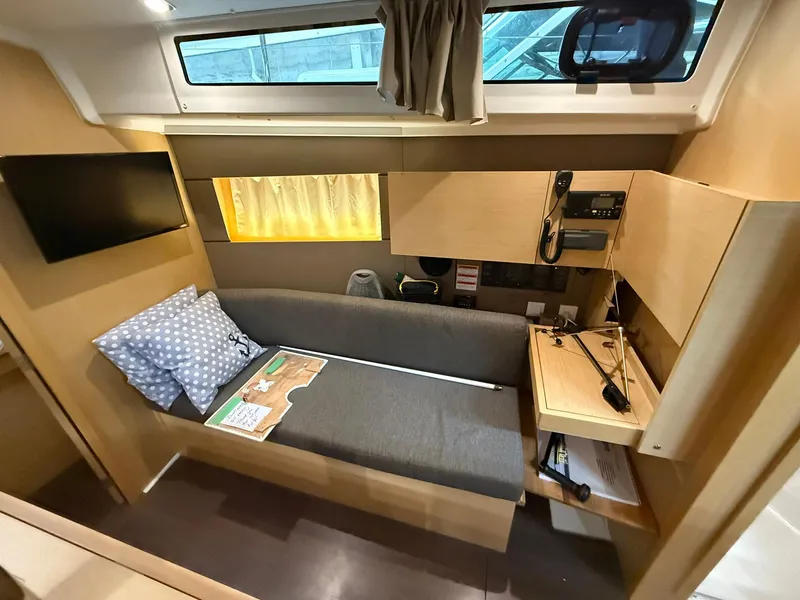 Slide: The Image of 2017 Beneteau Oceanis 38.1 interior with sofa, TV, and navigation equipment. - 41