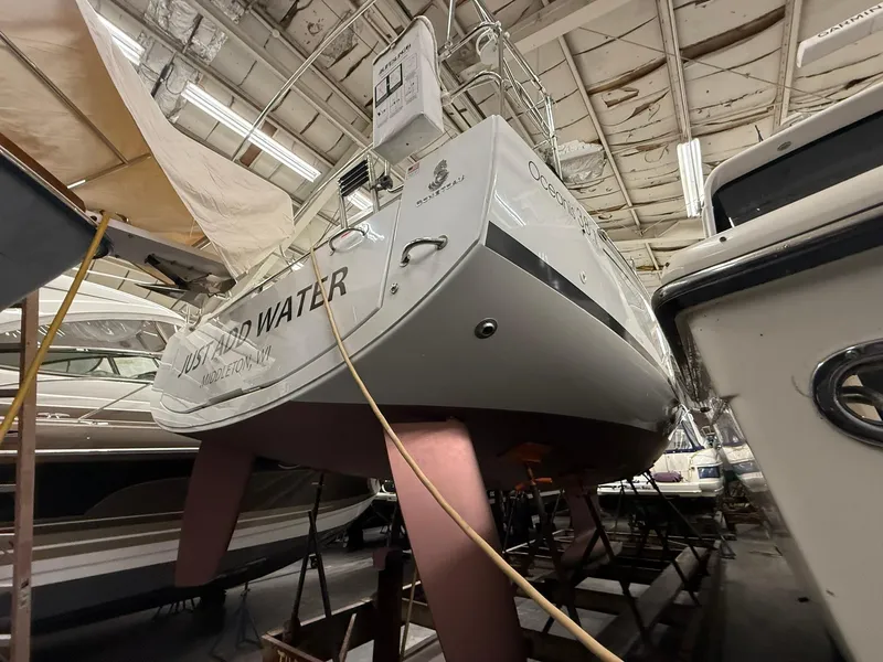 Slide: The Image of 2017 Beneteau Oceanis 38.1 sailboat in storage, viewed from the stern. - 44