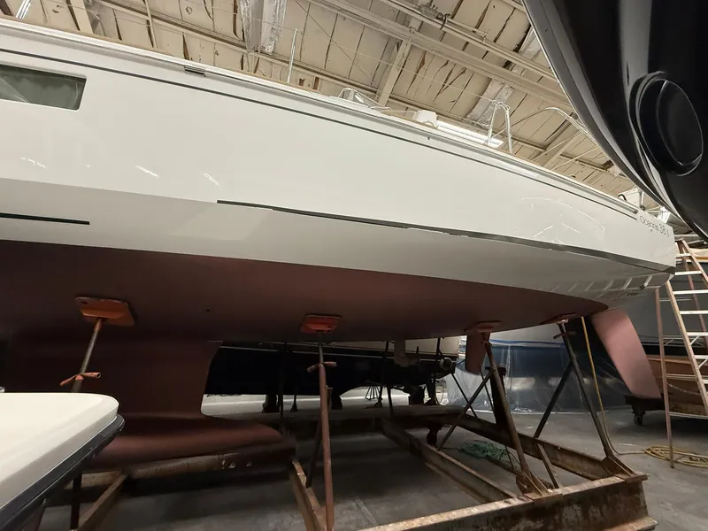 Slide: The Image of 2017 Beneteau Oceanis 38.1 sailboat in dry dock, viewed from the side. - 49