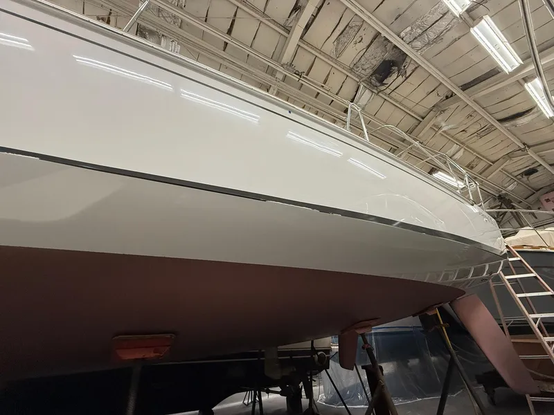 Slide: The Image of 2017 Beneteau Oceanis 38.1 sailboat in a warehouse, showcasing sleek hull design. - 50