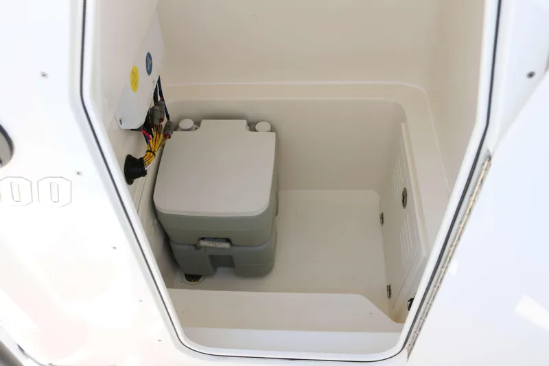 Slide: The Image of 2023 Pathfinder 2400TRS boat storage compartment with portable toilet. - 10