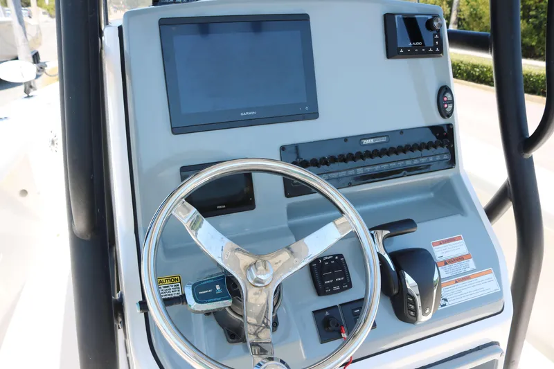 Slide: The Image of 2023 Pathfinder 2400TRS boat dashboard with steering wheel and electronic controls. - 6