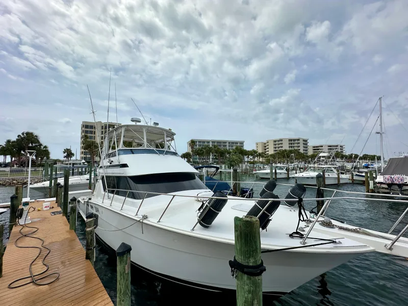 The Image of 1994 Hatteras 46 Convertible yacht docked at marina under cloudy sky. - 0