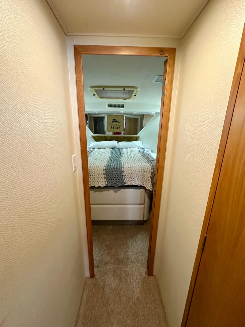 Slide: The Image of 1994 Hatteras 46 Convertible cabin interior with bed and cozy decor. - 115