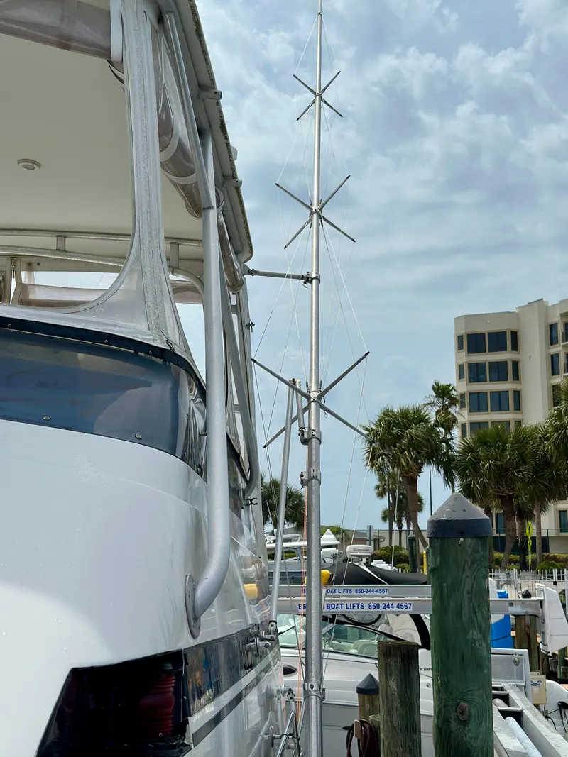 Slide: The Image of 1994 Hatteras 46 Convertible yacht docked with antenna, palm trees, and buildings in the background. - 14