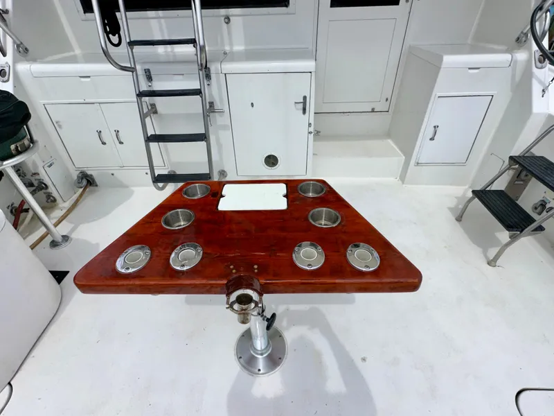 Slide: The Image of Cockpit of 1994 Hatteras 46 Convertible with wooden table and storage cabinets. - 16