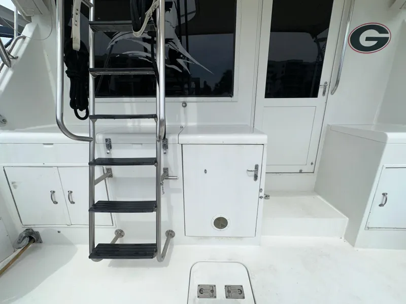 Slide: The Image of 1994 Hatteras 46 Convertible yacht deck with ladder and storage compartments. - 19