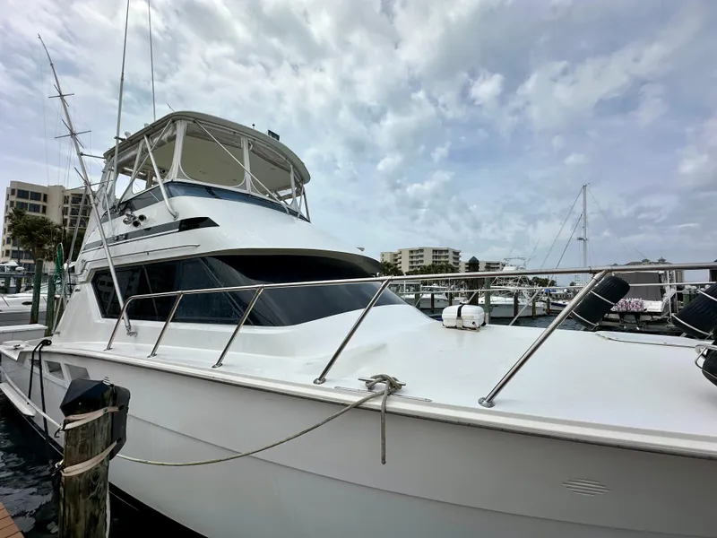 Slide: The Image of 1994 Hatteras 46 Convertible yacht docked at marina under cloudy sky. - 2