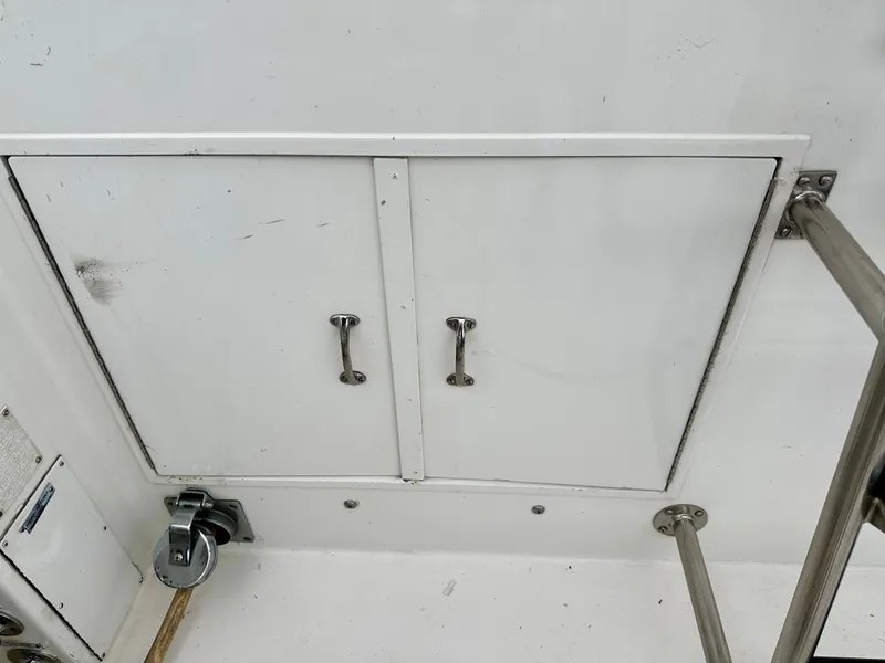 Slide: The Image of 1994 Hatteras 46 Convertible boat storage compartment with metal handles and railing. - 24