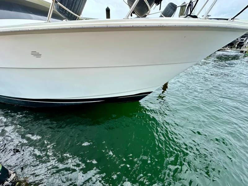 Slide: The Image of Hatteras 46 Convertible 1994 yacht bow in marina, white hull above green water. - 3