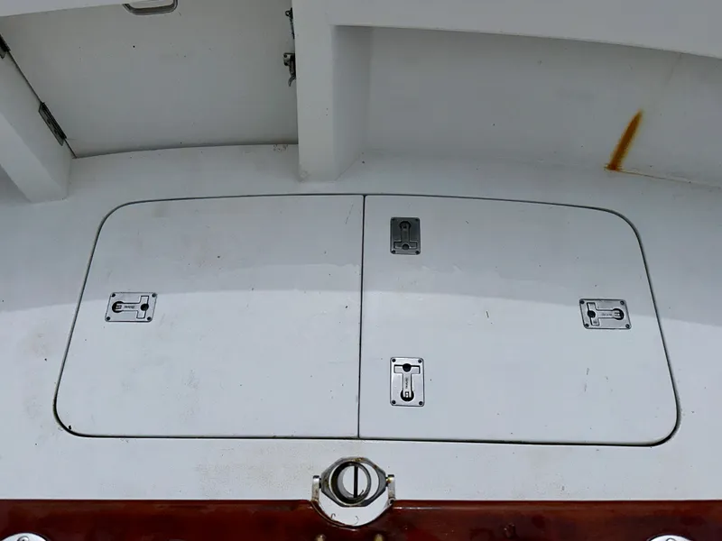 Slide: The Image of 1994 Hatteras 46 Convertible deck with storage hatches and metal latches. - 35
