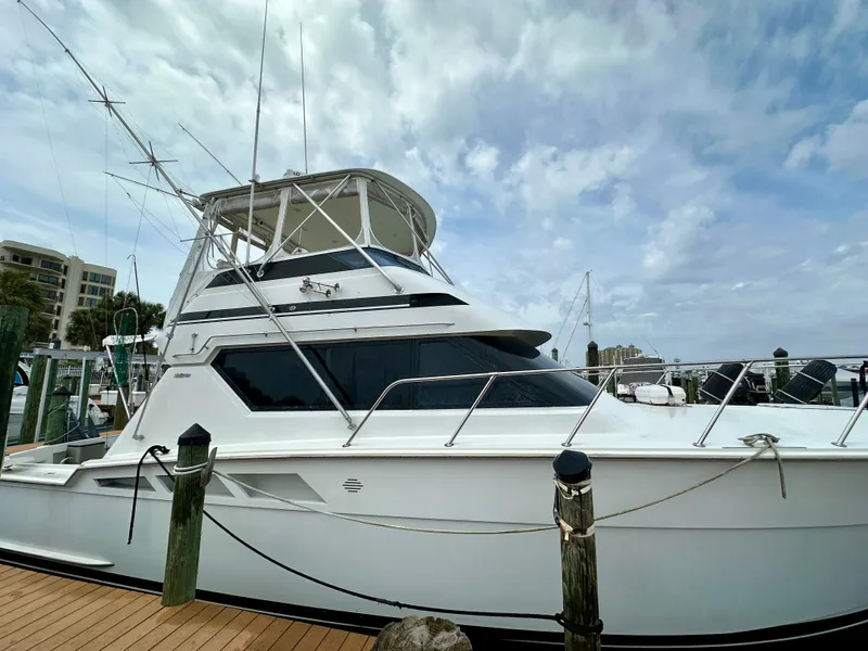 Slide: The Image of 1994 Hatteras 46 Convertible yacht docked under a cloudy sky. - 4