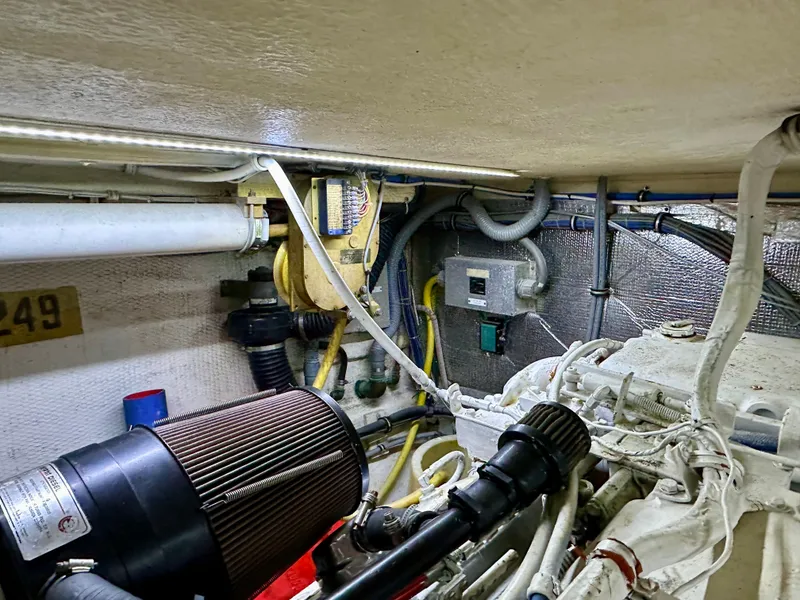 Slide: The Image of Engine room of 1994 Hatteras 46 Convertible yacht, showcasing mechanical components and wiring. - 44
