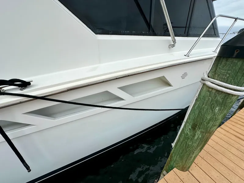 Slide: The Image of 1994 Hatteras 46 Convertible yacht docked, showcasing sleek white exterior and modern design. - 7