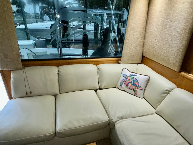 Slide: The Image of 1994 Hatteras 46 Convertible yacht interior with beige sofa and decorative pillow. - 73