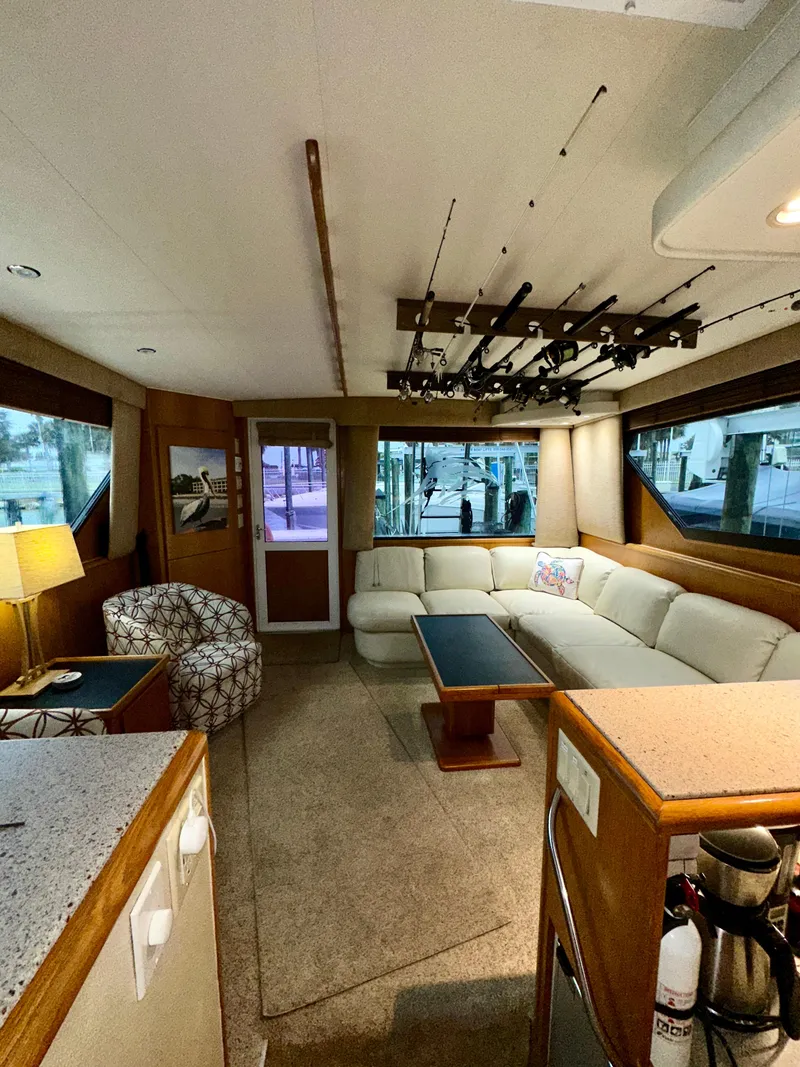 Slide: The Image of Interior of a 1994 Hatteras 46 Convertible yacht with cozy seating and fishing rod storage. - 81