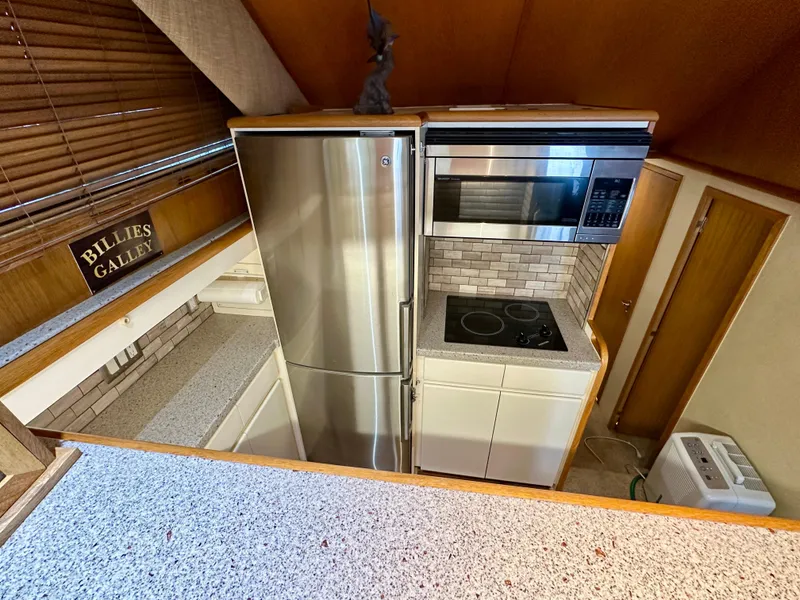 Slide: The Image of Kitchen area of 1994 Hatteras 46 Convertible yacht with modern appliances. - 85