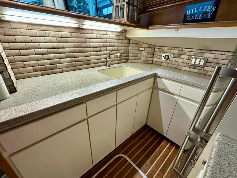Slide: The Image of 1994 Hatteras 46 Convertible yacht kitchen with modern countertops and brick backsplash. - 89
