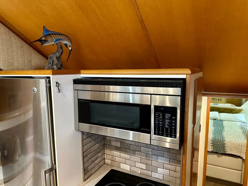 Slide: The Image of 1994 Hatteras 46 Convertible yacht kitchen with stainless steel microwave and marlin sculpture. - 90