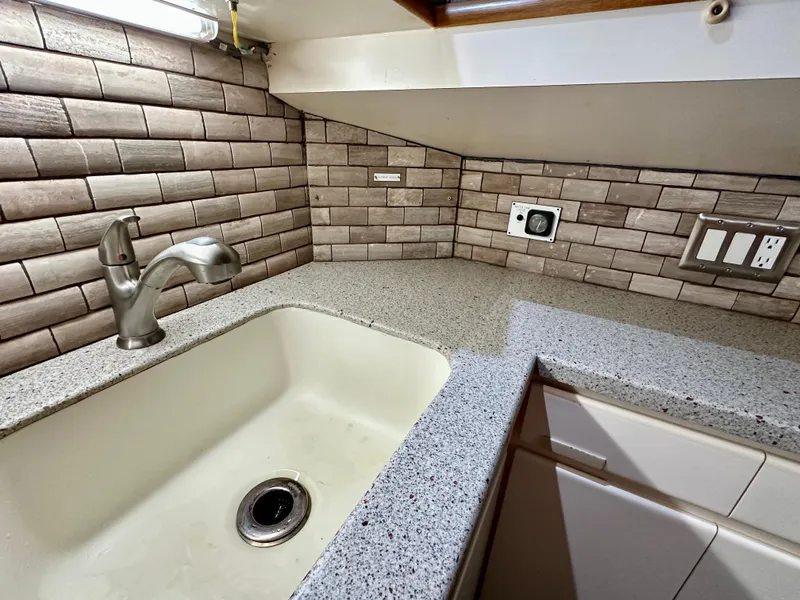 Slide: The Image of Kitchen sink area in a 1994 Hatteras 46 Convertible yacht with modern fixtures. - 93