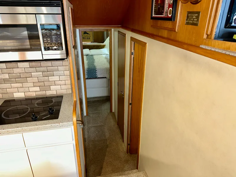 Slide: The Image of Interior of 1994 Hatteras 46 Convertible yacht, featuring kitchen and hallway leading to bedroom. - 94