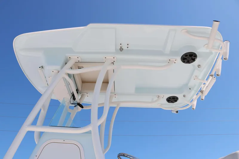 Slide: The Image of 2022 Sea Born FX25 Bay boat T-top with rod holders and speakers against blue sky. - 4