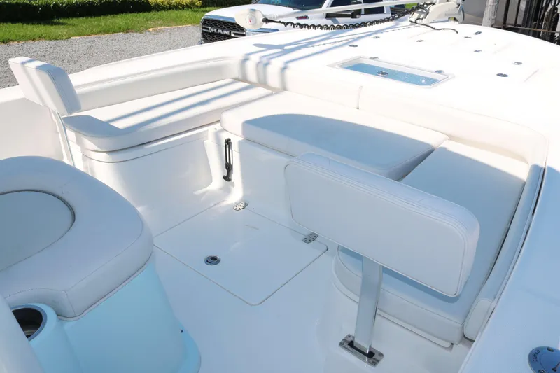 Slide: The Image of 2022 Sea Born FX25 Bay boat interior with white seating and storage compartments. - 8