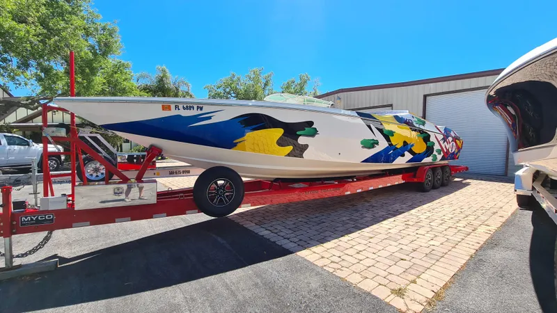 The Image of Cigarette Tiger 42 boat, 2000 model, with colorful design on a red trailer. - 0