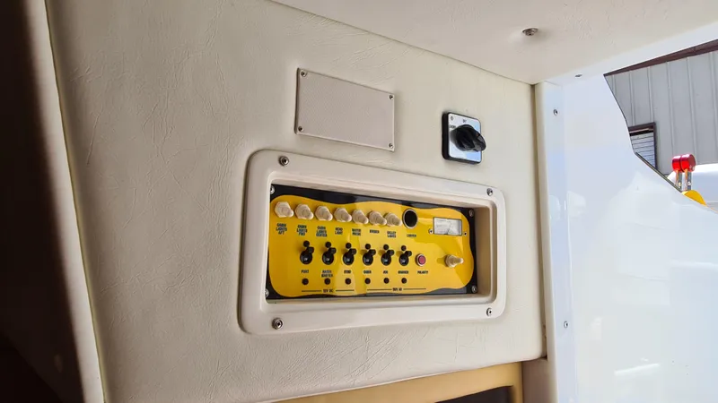 Slide: The Image of Control panel inside a 2000 Cigarette Tiger 42 boat, featuring various switches and dials. - 13