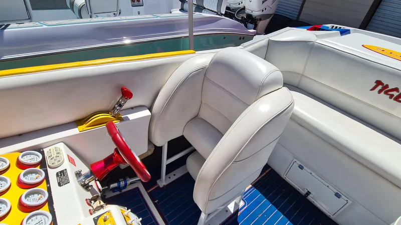 Slide: The Image of Interior of a 2000 Cigarette Tiger 42 boat with white seating and red steering wheel. - 19