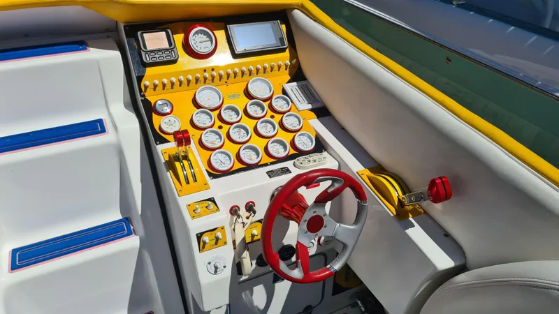 Slide: The Image of Control panel of a 2000 Cigarette Tiger 42 boat with gauges and red steering wheel. - 20