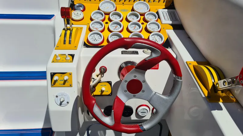Slide: The Image of Steering wheel and dashboard of a 2000 Cigarette Tiger 42 boat with gauges and controls. - 21
