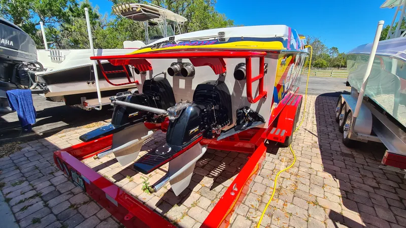 Slide: The Image of 2000 Cigarette Tiger 42 boat on trailer, featuring dual engines and vibrant design. - 29