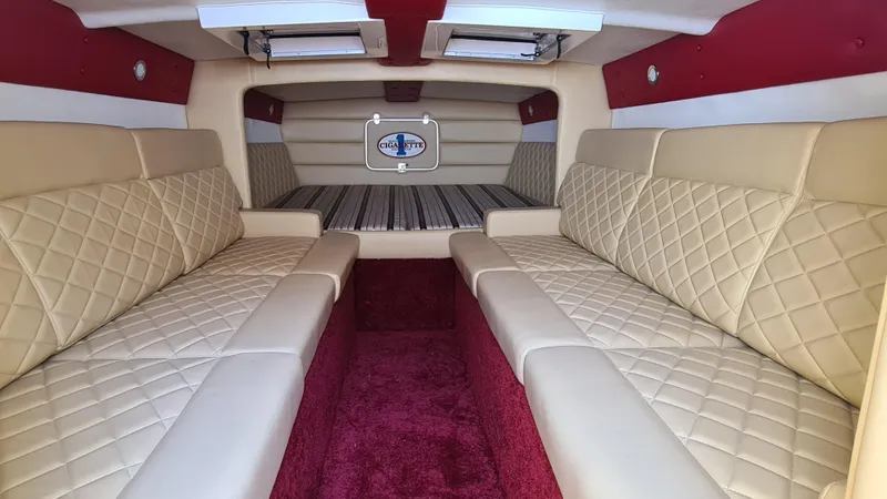 Slide: The Image of Interior of 2000 Cigarette Tiger 42 boat with beige quilted seating and red accents. - 9