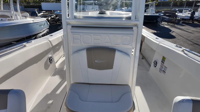Slide: The Image of 2025 Robalo R230 boat interior with seating and branding in a marina setting. - 10