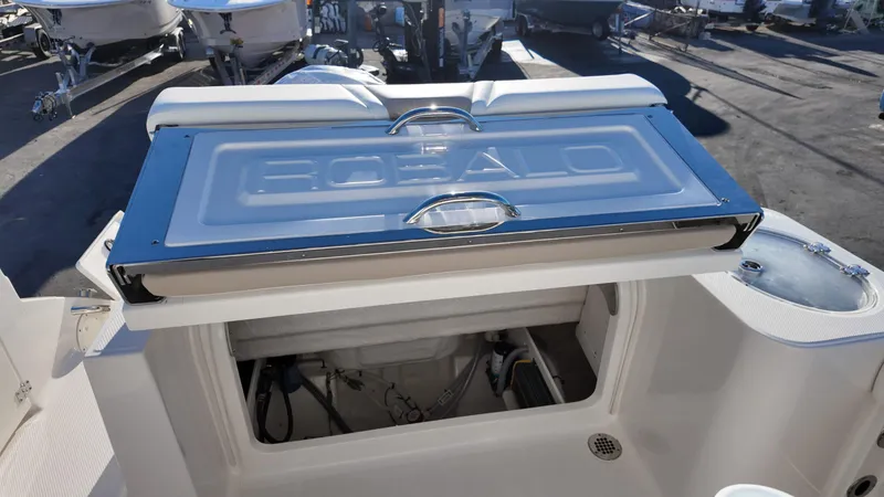 Slide: The Image of 2025 Robalo R230 boat with open storage compartment and visible interior components. - 13