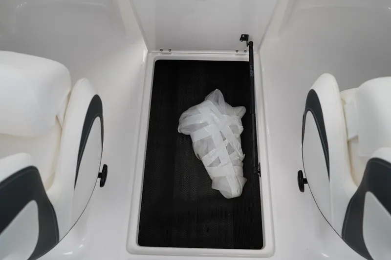 Slide: The Image of 2025 Chaparral 21 SSi OB boat dashboard with storage compartment and cup holder. - 22