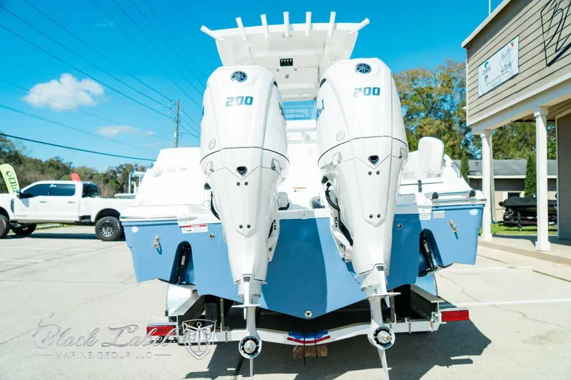 Slide: The Image of 2025 Sea Fox 268 Commander boat with dual 200 horsepower engines, parked outdoors. - 4