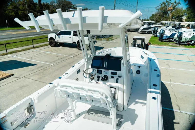 Slide: The Image of 2025 Sea Fox 268 Commander boat with modern console and seating, parked outdoors. - 9