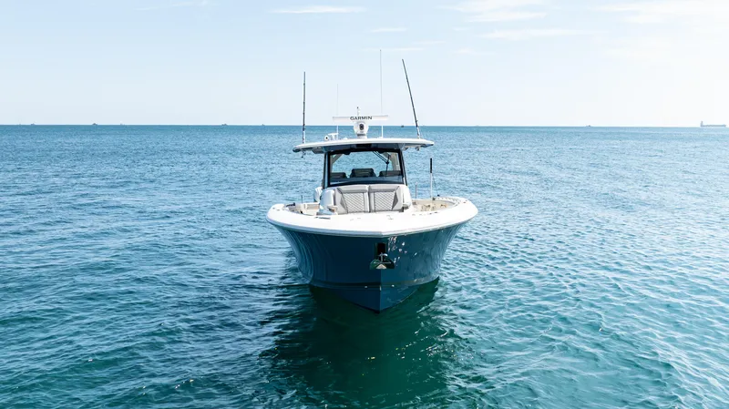 Slide: The Image of 2021 Pursuit 428 boat on open sea under clear sky. - 0