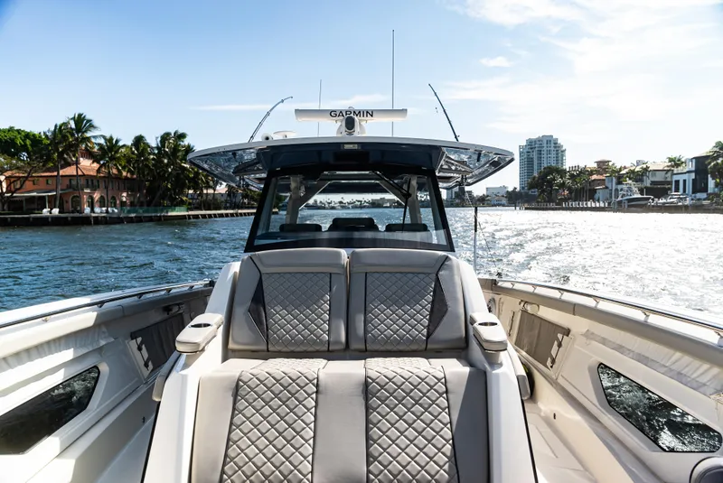Slide: The Image of Luxurious 2021 Pursuit 428 boat cruising on a sunny waterfront with plush seating. - 4