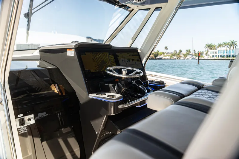 Slide: The Image of 2021 Pursuit 428 boat helm with modern controls and ocean view. - 7