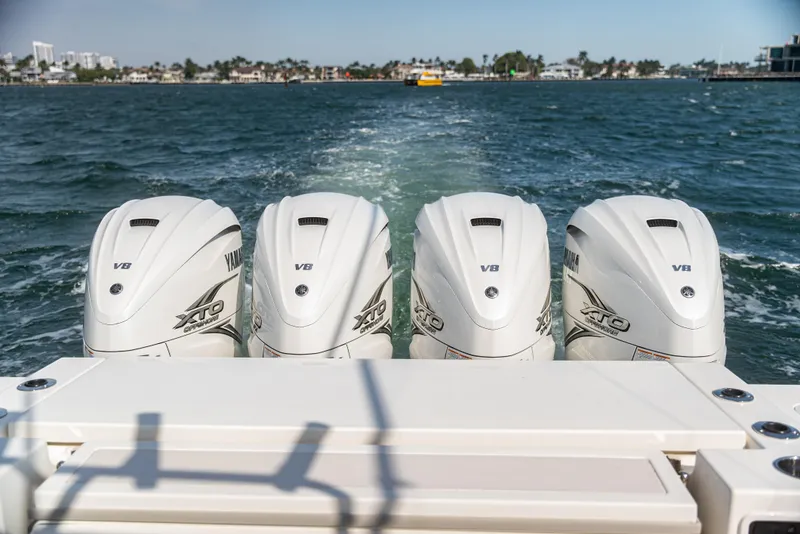 Slide: The Image of Four Yamaha V8 outboard engines on a 2021 Pursuit 428 boat, cruising on open water. - 9