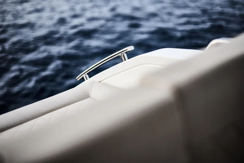 Slide: The Image of Skamander Sorrento 2025 boat detail with chrome railing against ocean backdrop. - 22