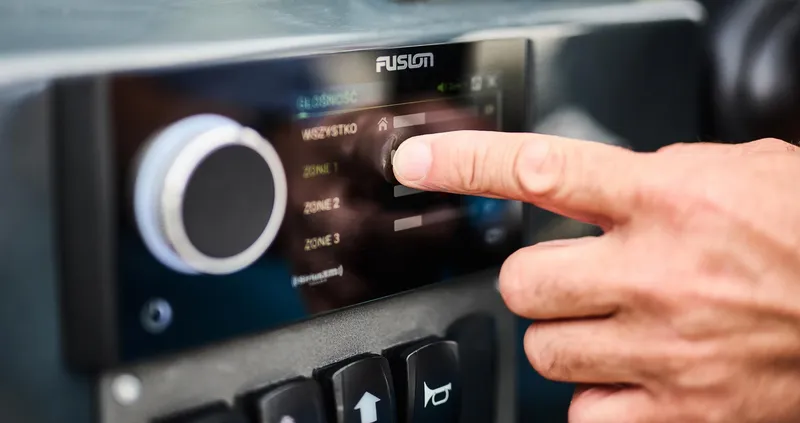 Slide: The Image of Close-up of a hand adjusting a Fusion audio system in a 2025 Skamander Sorrento. - 31