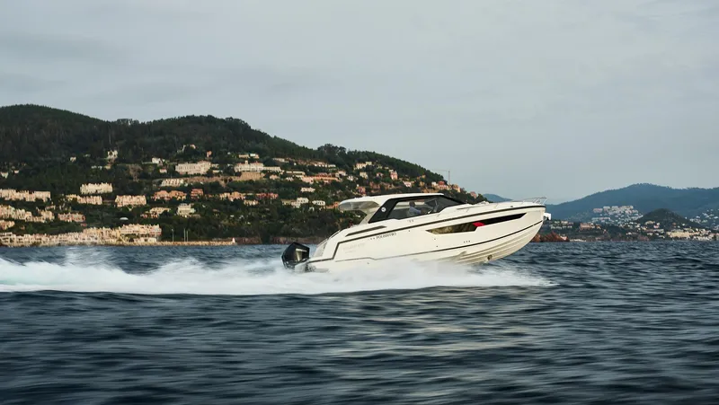 Slide: The Image of 2025 Skamander Sorrento boat cruising on open water with scenic hillside backdrop. - 34