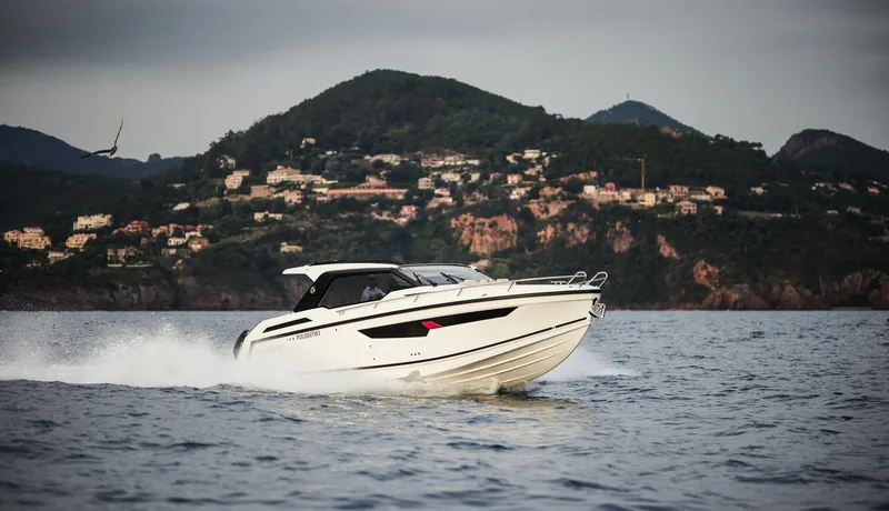 Slide: The Image of 2025 Skamander Sorrento boat cruising on water with scenic mountain backdrop. - 36