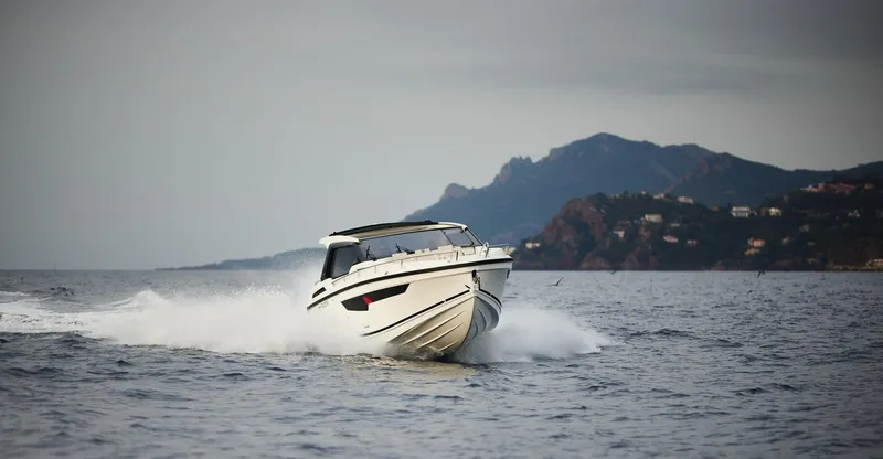 Slide: The Image of 2025 Skamander Sorrento boat cruising on open water with scenic mountain backdrop. - 38