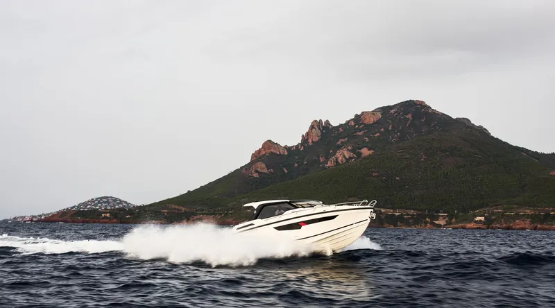 Slide: The Image of 2025 Skamander Sorrento boat cruising near a scenic mountainous coastline. - 48